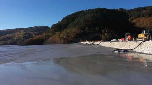 Aerial view of mining residuals flowing into decanting pond from a copper mine. Geamana, Romania