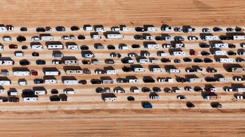 Lots of cars and campervans move slowly by the multi-lane road in the desert.