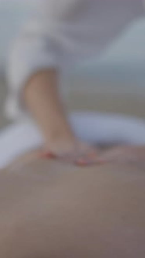 Unrecognizable Man Gets Relaxing Back Massage at the Beach