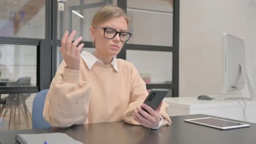 Female Worker Shocked by Loss on Phone in Office