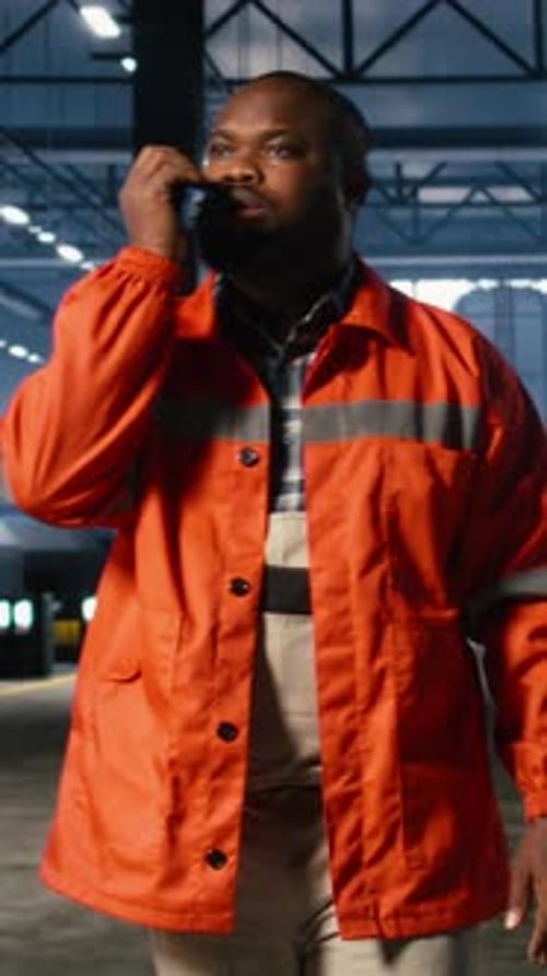 Vertical Video Black Operator Talks Through Walkie Talkie and Monitoring Metal Fabrication