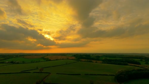 Sunset Lighting Agricultural Landscape with Golden Rays Breaking Through Clouds Evening Sky Covering