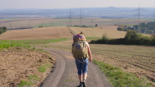 Woman Hiker Walks Rural Trail with Backpack