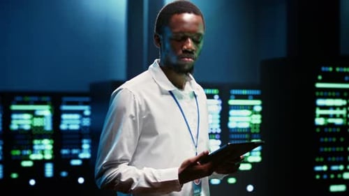 Afroamerikanischer Programmierer verwendet Tablet zur Inspektion von Rackmount-Servern