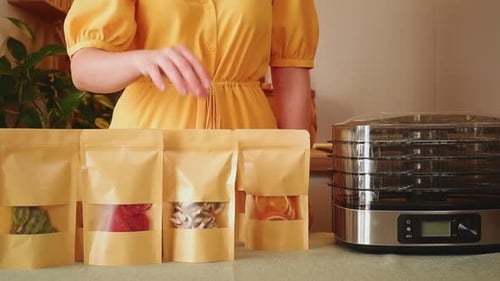 Woman Packaging Colorful Dehydrated Fruit at Home