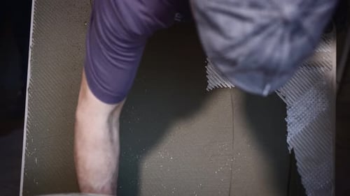 Construction Worker Applying Cement with Trowel to Surface