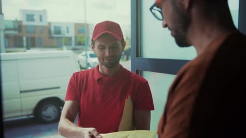 Man signs for a package delivered to his house
