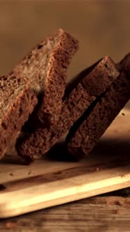Super Slow Motion Pieces of Fragrant Bread Fall on the Cutting Board Filmed on a Highspeed Camera at