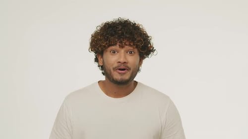 Front View of Young Man Hearing Good News Studio Footage of Excited Guy with Surprised Smile Shocked