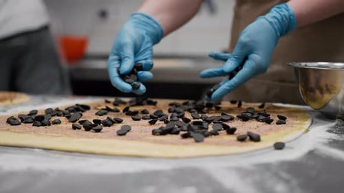 Chocolate Chips Being Placed on Dough for Pastry