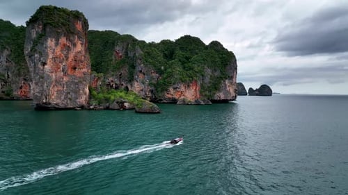 Longboat Sailing In Tonsai Bay With Limestone Cliffs In Ao Nang, Krabi Thailand. - aerial follow