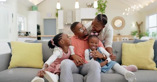 Happy Family Smiling and Laughing on Couch