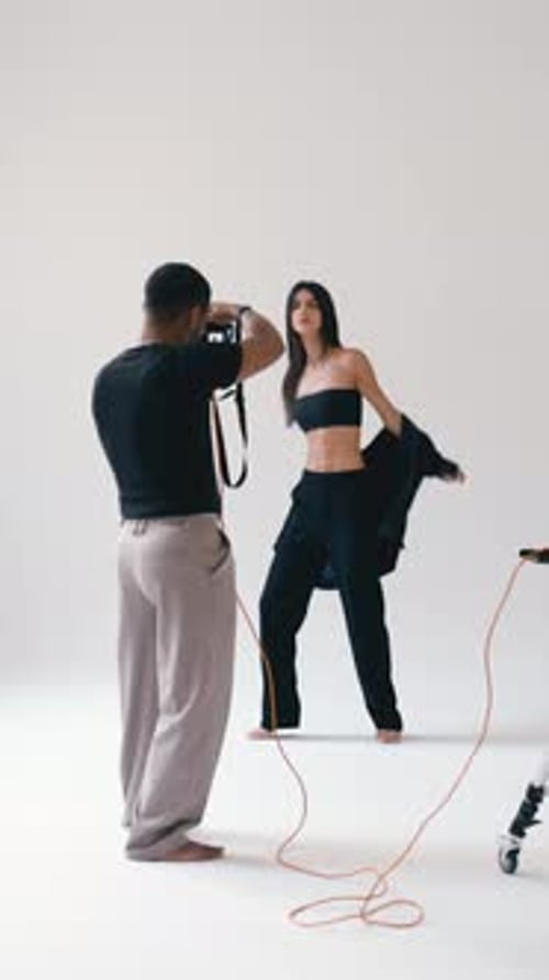 Professional Photographer Taking Pictures of Fashion Model in Studio Vertical