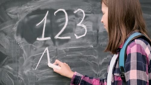 Teenager-Studentin in Hemd mit blauem Rucksack, Schrift mit Kreide, Zahlen und Buchstaben auf Schwarz