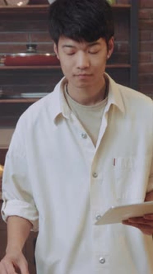 Young Man smiles at camera preparing food
