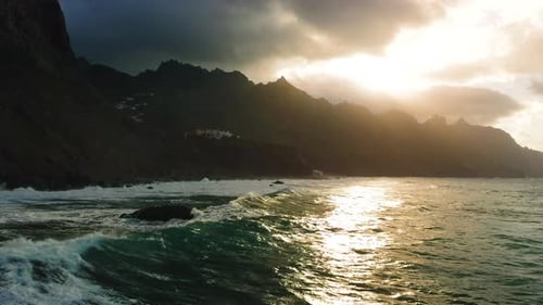 Sunset Over Ocean Waves Wash Rocky Beach