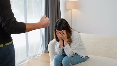 Upset Woman Sits with Man Clenching Fist