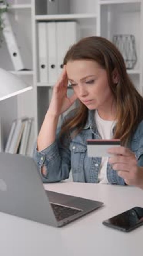 A Woman Looks at Her Computer Screen with Concern Her Eyes Expressing Thoughtfulness and Sadness She