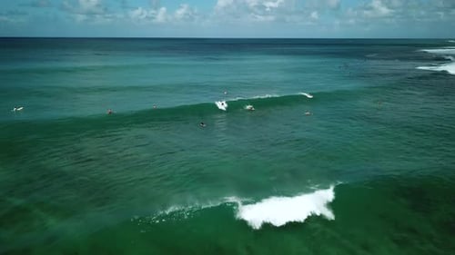 Drone shot approaching a female surfer riding a wave on the North Shore Coast of Oahu, Hawaii.