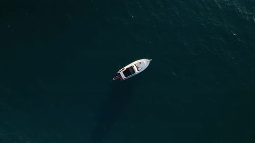 Aerial Drone Tracking Top Down Video of Yacht Cruising in Deep Blue Open Ocean Sea