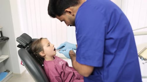 Dentist Inspecting Child's Teeth in Office