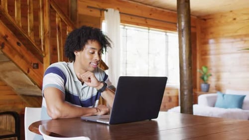 Young Adult Using Laptop Computer at Home