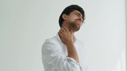 Studio Portrait of Frustrated Bearded Young Man Massaging Painful Wrist Suffering Hand Sprain or