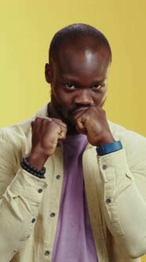 Homme contemplatif exprimant des émotions profondes sur une couleur de fond jaune vif