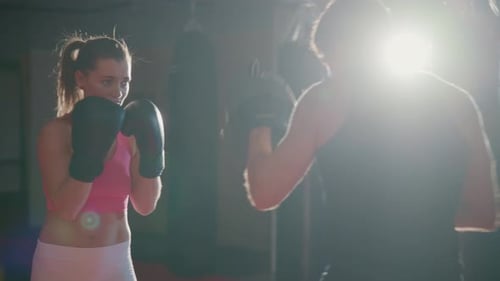 Woman Boxing with Trainer in Gym