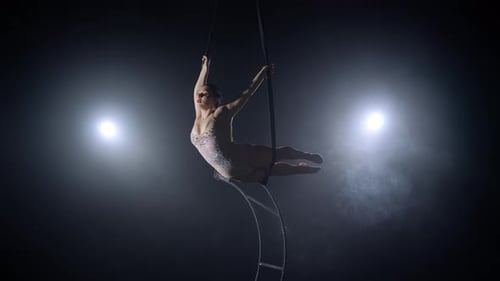 Woman Performing Elegant Aerial Acrobatics in Dark Setting