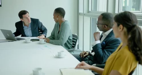 Businessman Leading Meeting in the Office Board room Presenting to Team