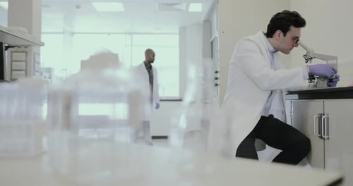 Male scientist looking at microscope