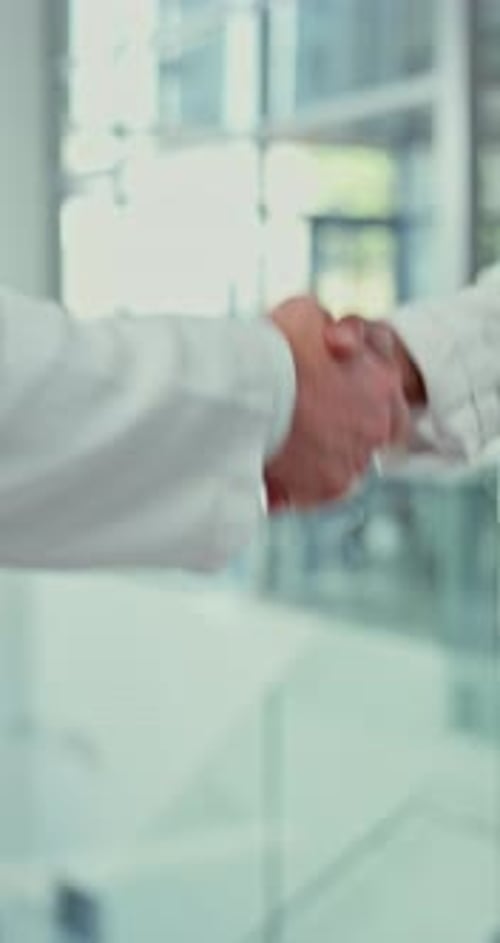 Handshake Between Two People in Lab Coats
