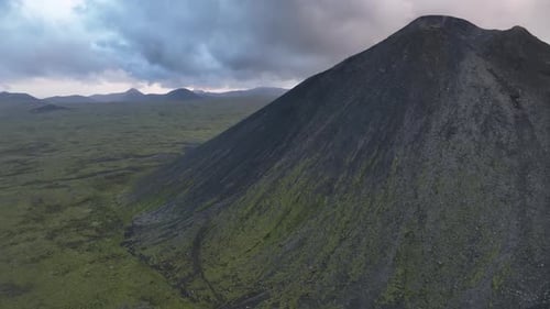 A panoramic shot across a field of rocks and moss-covered mountains