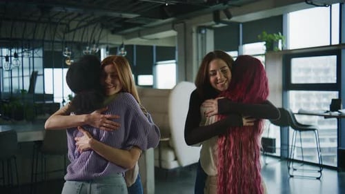 Four Women Share a Moment During a Support Session in a Modern Community Center They Embrace Each