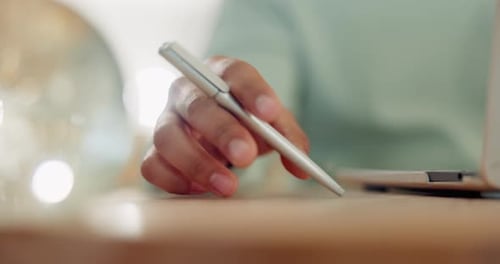 Laptop, hand and holding a pen on a table for remote work, research and information technology