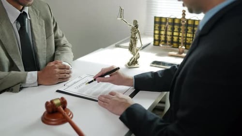 Two Men Signing a Contract in Office