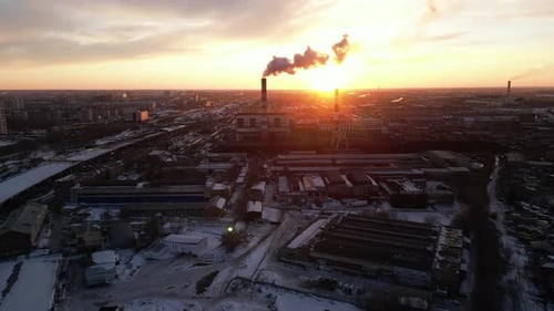 Chemical manufacturing at sunset. Silhouette of a factory in city in the evening.