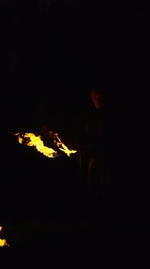 Des flammes enflammées illuminent le ciel nocturne lors d'une performance théâtrale en plein air avec Glowing