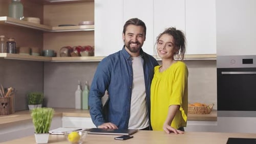 Smiling Couple Embracing in Modern Kitchen