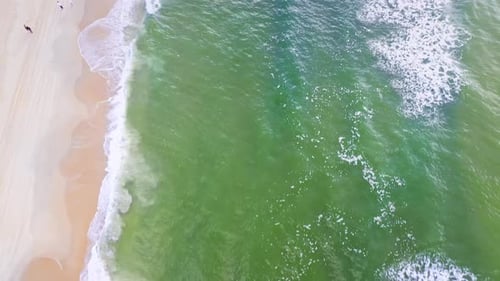 Aerial Top view of a transparent blue sea with beautiful waves at sunny day in summer. air of ocean