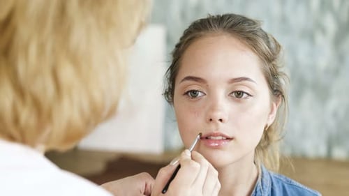 Teen Getting Lip Gloss Applied by Makeup Artist