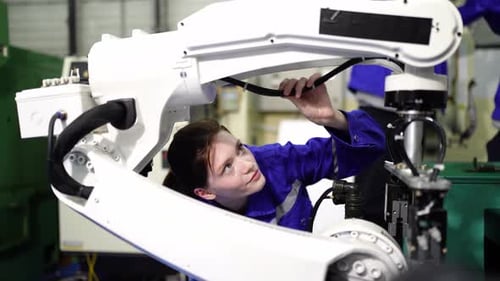 Engenheiros inspecionando e verificando a máquina automatizada de robôs de soldagem de máquinas de armas na fábrica.