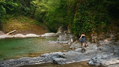 Wanderin läuft an schönem Sommertag im Fluss Kreatives Paradies-Wasserreservoir im Dschungel