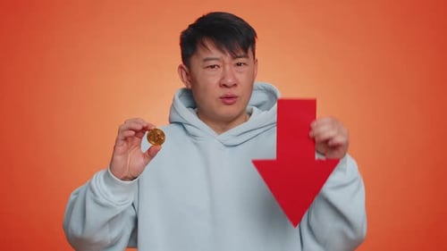Asian Man Show Bitcoins BTC Down Sign Decrease of Exchange Rate Fall of Stock Cryptocurrency Market