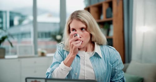 Woman Using Inhaler for Asthma Treatment Indoors