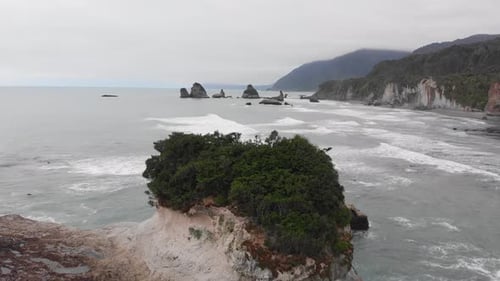 Aerial view of New Zealand coast on an overcast windy summer day. Rock formations washed by ocean wa