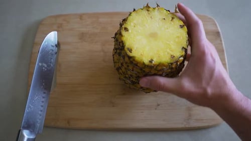 Man Places Pineapple on Cutting Board and Begins to Prepare the Delicious Fruit. First Person POV