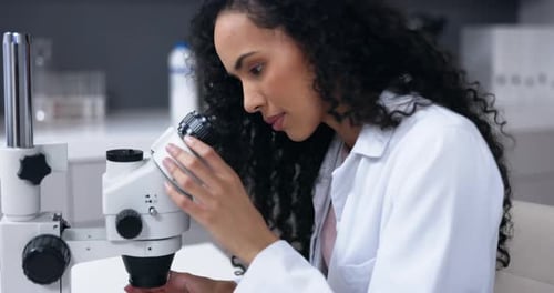 Female Scientist Using Microscope in Bright Laboratory