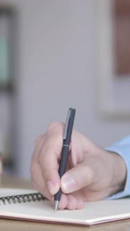 Hand Writing in Notebook in Office Setting